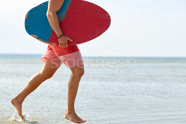 young man with skimboard on summer beach Stock photo © dolgachov