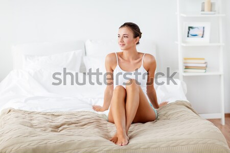 Mujer pluma tocar desnudo piernas cama Foto stock © dolgachov