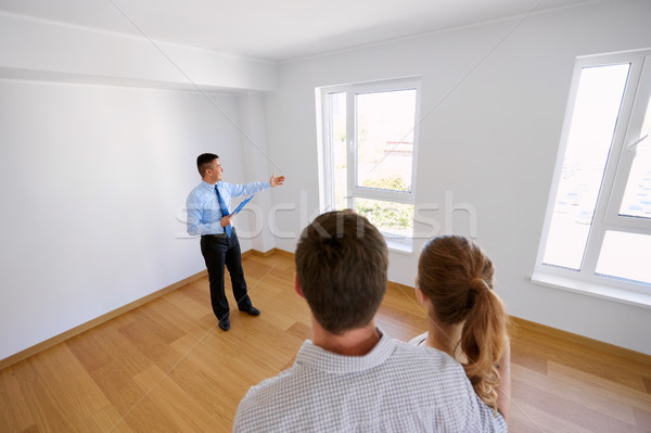 realtor with clipboard and couple at new home Stock photo © dolgachov