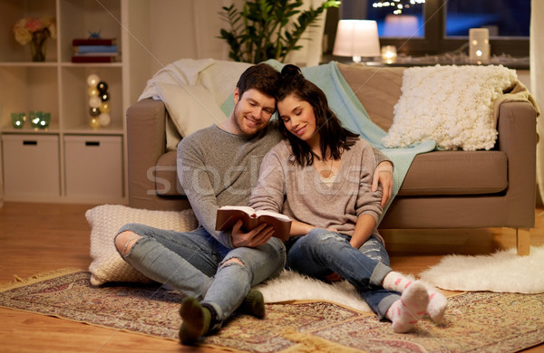 happy couple reading book at home Stock photo © dolgachov