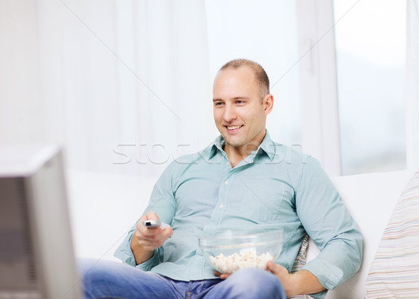 Uśmiechnięty człowiek popcorn oglądania film domu Zdjęcia stock © dolgachov