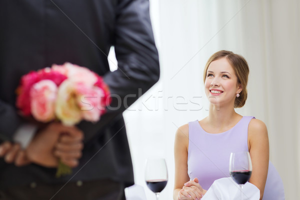 young woman looking at man with flower bouquet Stock photo © dolgachov