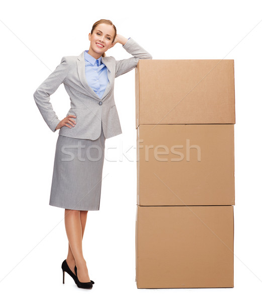 smiling businesswoman with cardboard boxes Stock photo © dolgachov