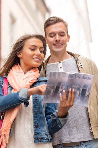 smiling couple with city guide exploring town Stock photo © dolgachov