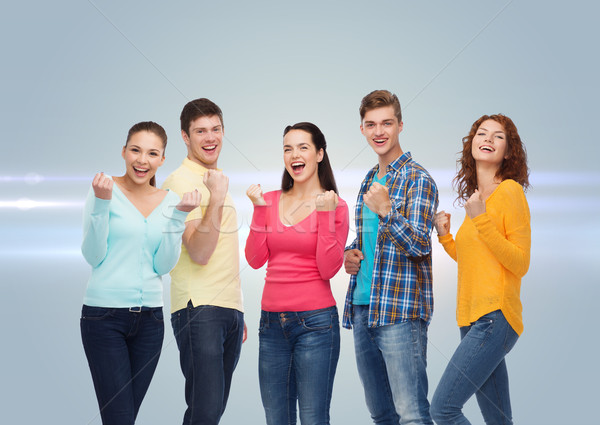 Groep glimlachend tieners tonen triomf gebaar Stockfoto © dolgachov