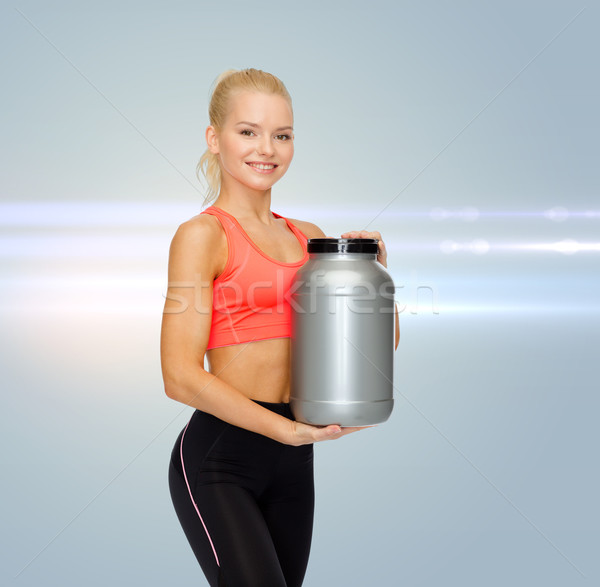 smiling sporty woman with jar of protein Stock photo © dolgachov