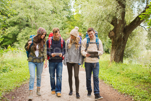 group of friends with backpacks and tablet pc Stock photo © dolgachov