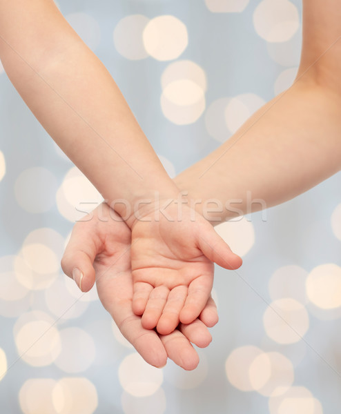 close up of woman and little child hands together Stock photo © dolgachov