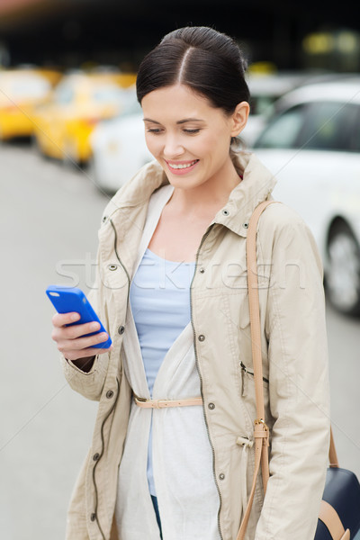 Сток-фото: улыбающаяся · женщина · смартфон · такси · город · путешествия · командировка