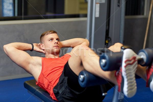 young man making abdominal exercises in gym Stock photo © dolgachov