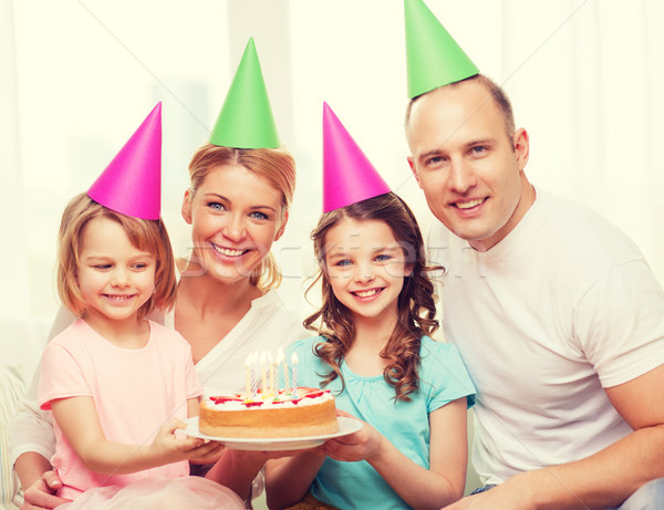 smiling family with two kids in hats with cake Stock photo © dolgachov