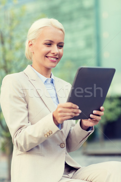 smiling businesswoman with tablet pc outdoors Stock photo © dolgachov