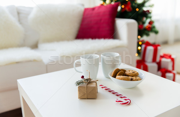 close up of gift, sweets and cups on table at home Stock photo © dolgachov