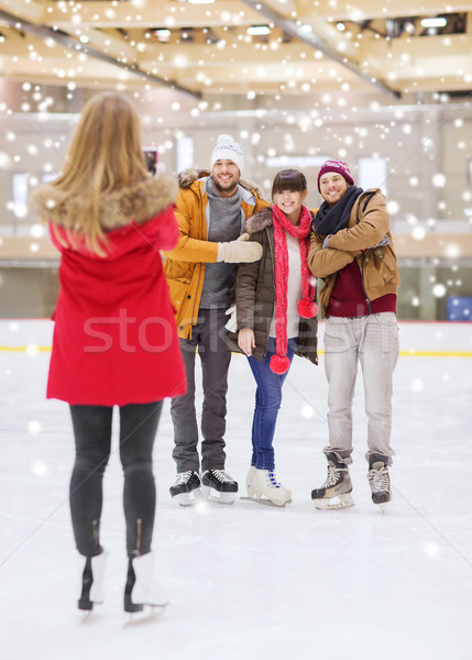 Stock photo: happy friends taking photo on skating rink