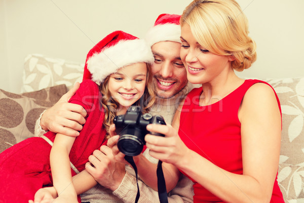 Stock photo: family in santa helper hats looking at pictires