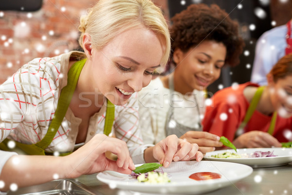 happy women cooking and decorating dishes Stock photo © dolgachov