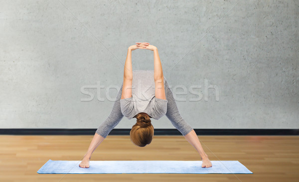 woman making yoga in wide-legged forward bend pose Stock photo © dolgachov