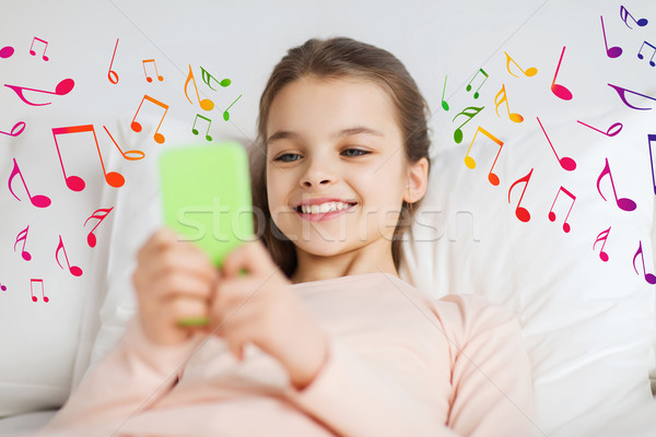 快樂的女孩 床 智能手機 筆記 人 孩子 商業照片 © dolgachov