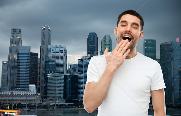 yawning man over evening singapore city background Stock photo © dolgachov