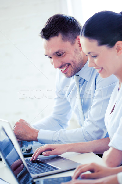 Férfi nő dolgozik laptop iroda mosolyog Stock fotó © dolgachov