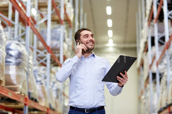 man with clipboard and smartphone at warehouse Stock photo © dolgachov