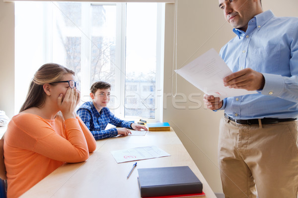 group of students and teacher with test results Stock photo © dolgachov