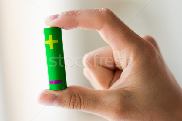 close up of hand holding green alkaline battery Stock photo © dolgachov