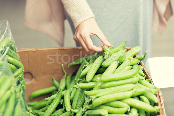 woman hand choosing green peas at street market Stock photo © dolgachov