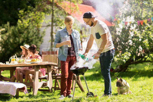 friends making barbecue grill at summer party Stock photo © dolgachov