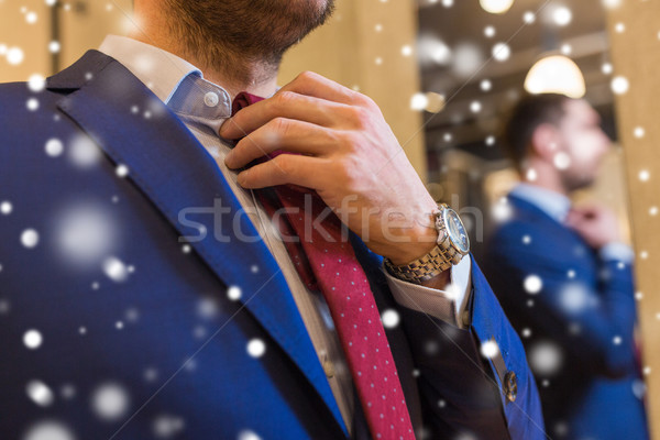 close up of man trying tie on at clothing store Stock photo © dolgachov