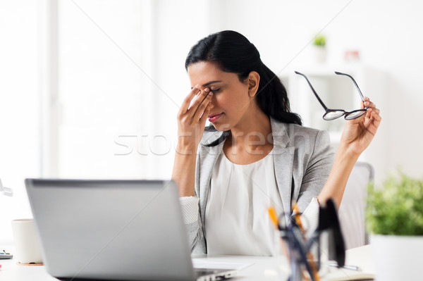 businesswoman rubbing tired eyes at office Stock photo © dolgachov