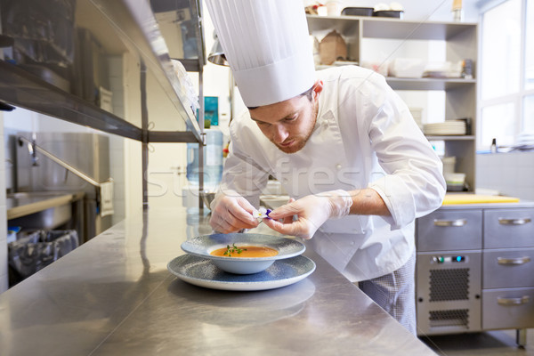 happy male chef cooking food at restaurant kitchen Stock photo © dolgachov