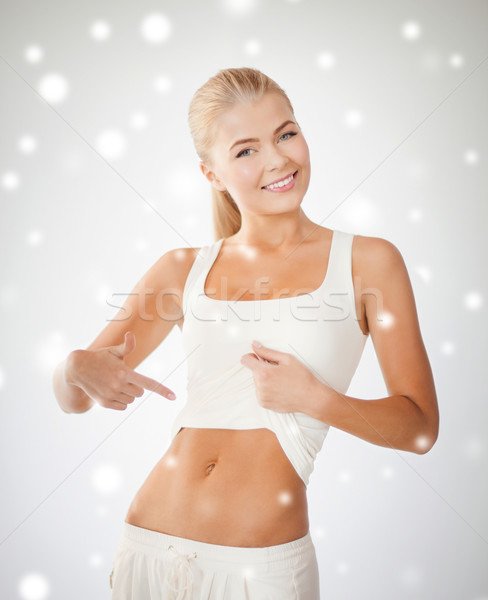 beautiful sporty woman pointing at abs Stock photo © dolgachov
