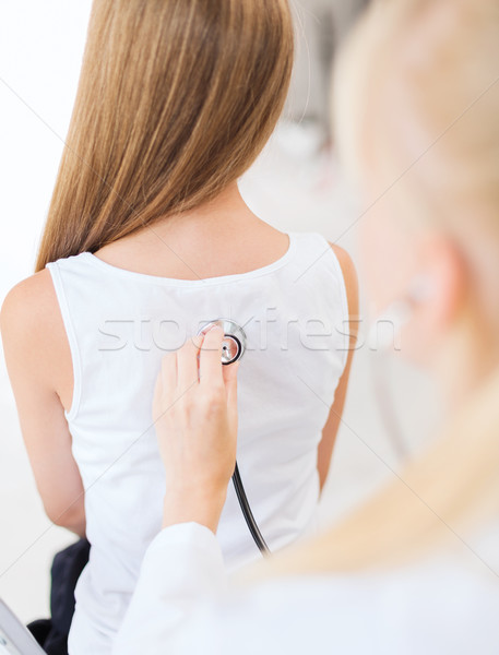 doctor with stethoscope listening to child back Stock photo © dolgachov