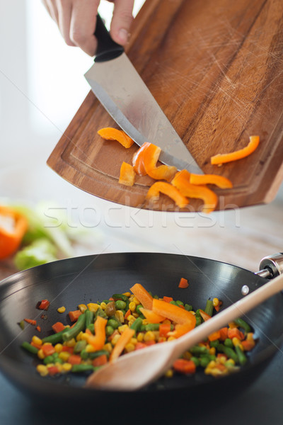 close up of male hand adding peppers to wok Stock photo © dolgachov