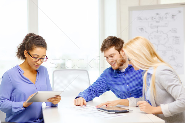 Stock photo: smiling team with table pc and papers working