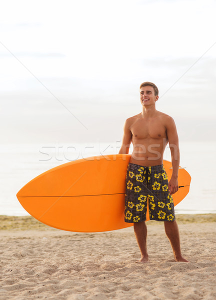 Uśmiechnięty młody człowiek deska surfingowa plaży morza Zdjęcia stock © dolgachov