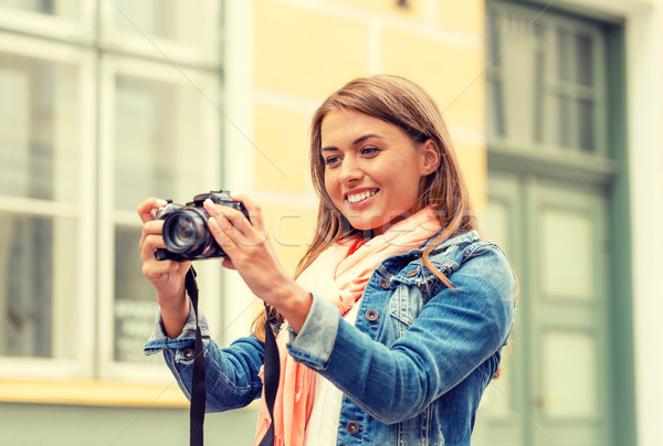 smiling girl with digiral photocamera in the city Stock photo © dolgachov