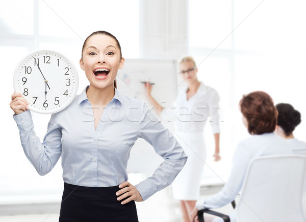 attractive businesswoman with wall clock Stock photo © dolgachov