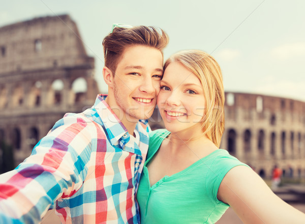 smiling couple taking selfie over coliseum Stock photo © dolgachov
