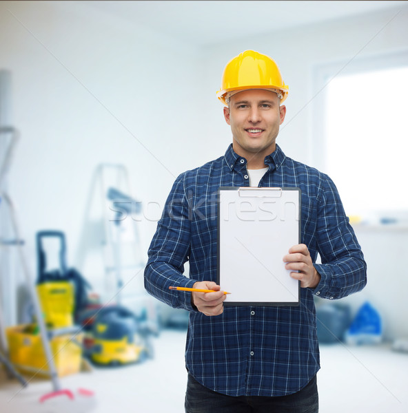 smiling male builder in helmet with clipboard Stock photo © dolgachov