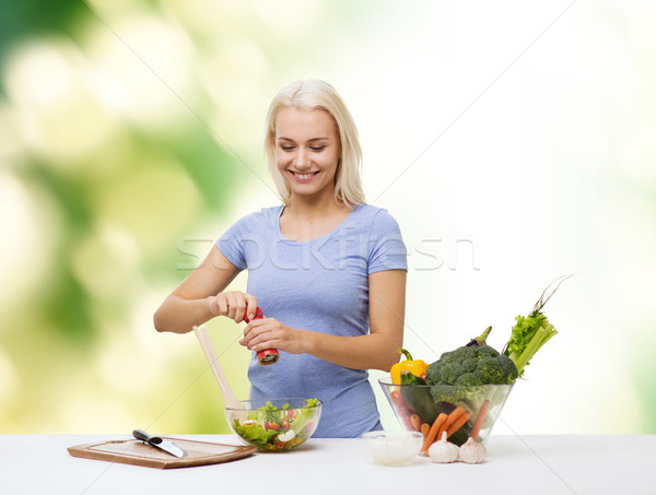 smiling woman cooking vegetable salad Stock photo © dolgachov