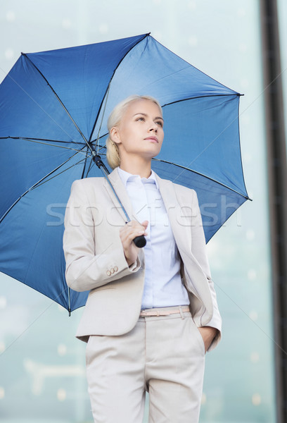 young serious businesswoman with umbrella outdoors Stock photo © dolgachov
