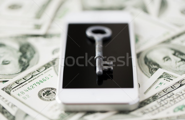 close up of smartphone with key and dollar money Stock photo © dolgachov