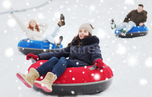 group of happy friends sliding down on snow tubes Stock photo © dolgachov