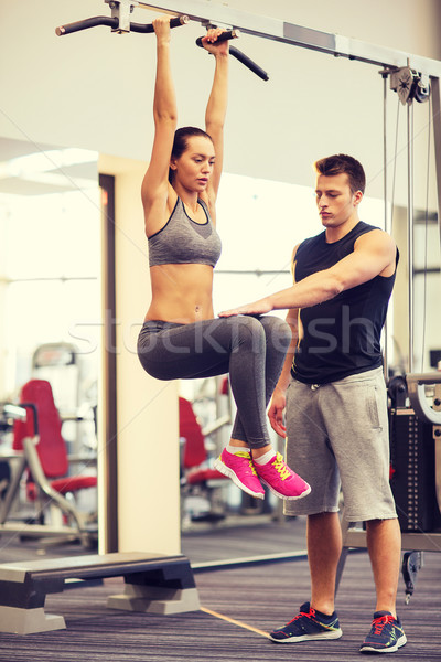 young woman with trainer doing leg raises in gym Stock photo © dolgachov