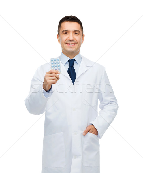 smiling male doctor in white coat with tablets Stock photo © dolgachov