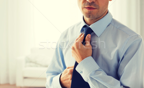 close up of man in shirt adjusting tie on neck Stock photo © dolgachov