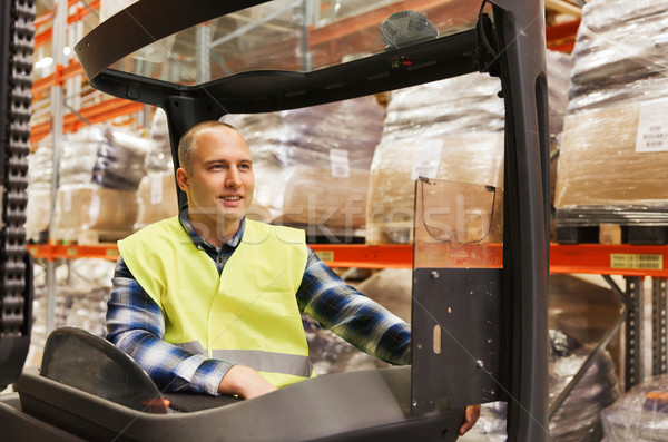 smiling man operating forklift loader at warehouse Stock photo © dolgachov