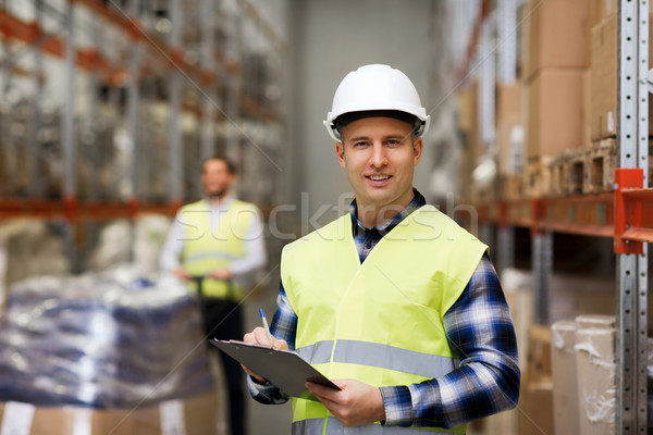 man with clipboard in safety vest at warehouse Stock photo © dolgachov